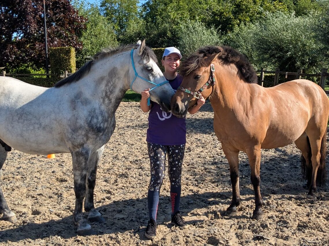 Lot staat in de piste met haar twee paarden.